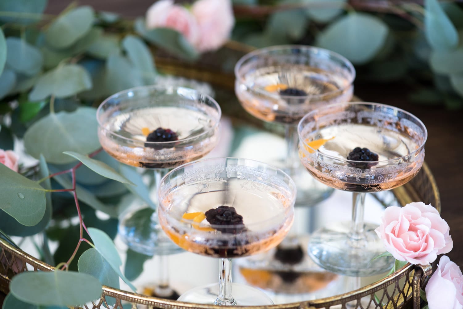 Four elegant mixed drinks on glass tray