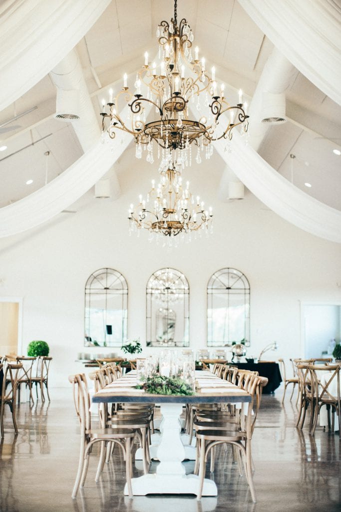 Dinner table and chandeliers at indoor outdoor wedding venue, The Greystone Estate.