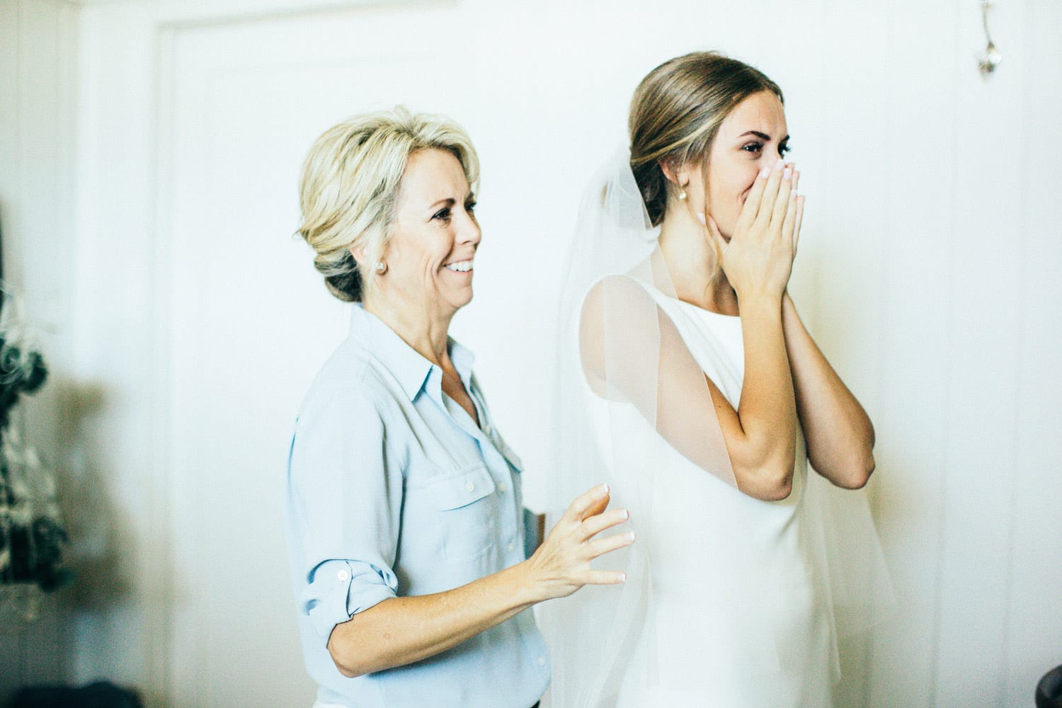 Bride and mother of the bride react to the mirror
