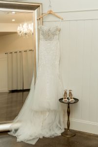 Bride's wedding dress hanging by mirror in bridal suite at The Greystone Estate wedding venue