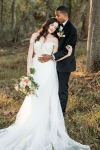 Groom holding and kissing the bride's forehead in the woods at a north Georgia wedding venue