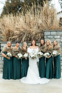 Bride and bridesmaids in green dresses and fur shawls at a north Georgia wedding venue