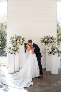 Bride and groom kiss each other inside outdoor white chapel at a north Georgia wedding venue